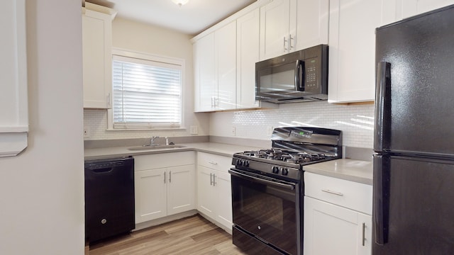 kitchen featuring black appliances, decorative backsplash, white cabinets, and sink