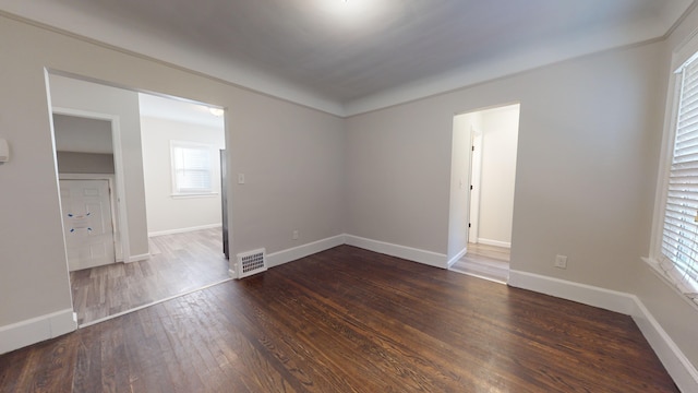 unfurnished room with dark wood-type flooring