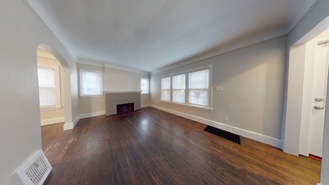 unfurnished living room featuring dark hardwood / wood-style floors and a brick fireplace