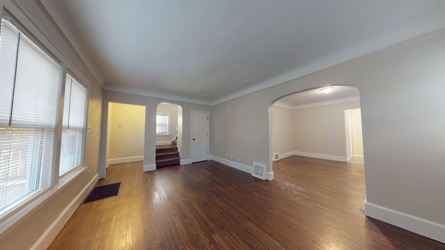 spare room featuring dark hardwood / wood-style floors and crown molding