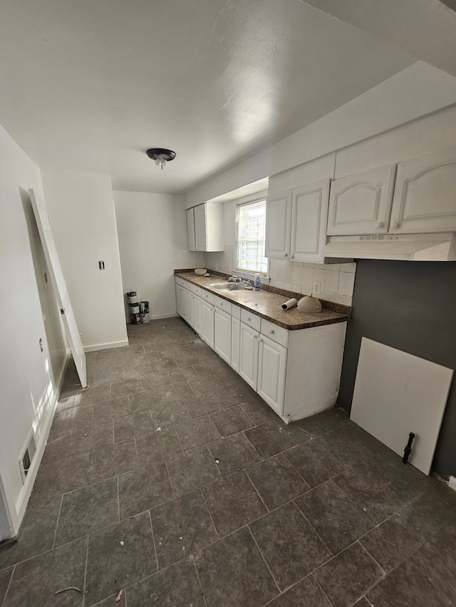 kitchen featuring white cabinetry and sink