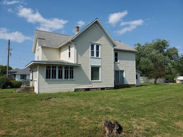 409 N Nottawa St, Sturgis, MI 49091 - rear view of house with a chimney, a yard, and roof with shingles