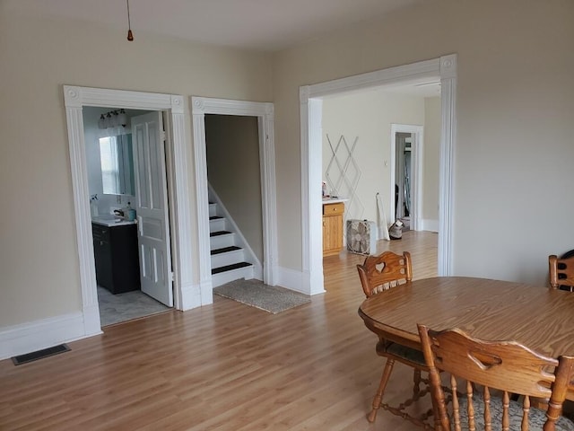 409 N Nottawa St, Sturgis, MI 49091 - dining room featuring light wood-style flooring, stairway, and baseboards