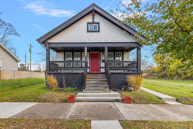 bungalow-style home with covered porch and a front yard