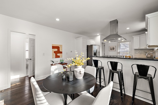 dining space with dark hardwood / wood-style flooring and sink