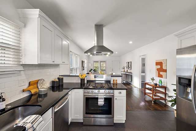 2552 Beals St, Detroit, MI 48214 - kitchen featuring stainless steel appliances, island range hood, a peninsula, dark countertops, and white cabinetry