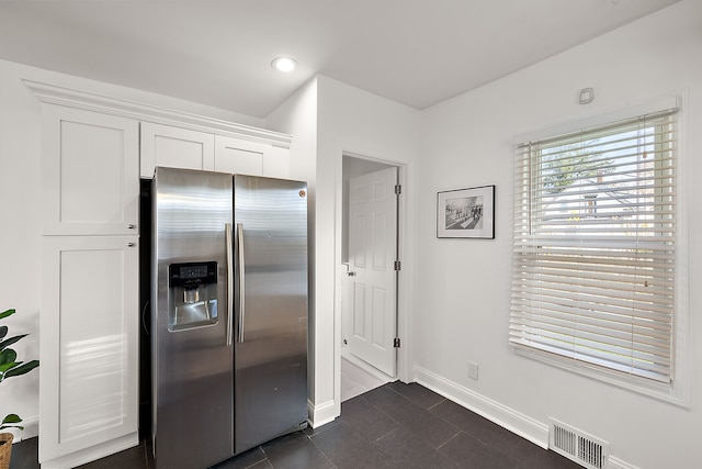 kitchen featuring white cabinetry and stainless steel fridge