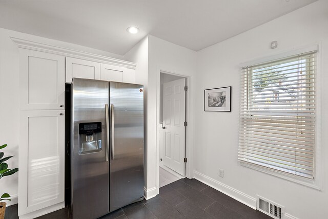 2552 Beals St, Detroit, MI 48214 - kitchen with stainless steel fridge, baseboards, white cabinetry, dark tile patterned flooring, and recessed lighting