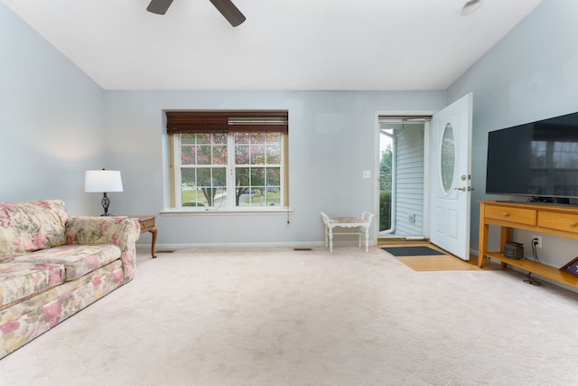 carpeted living room with ceiling fan and a healthy amount of sunlight