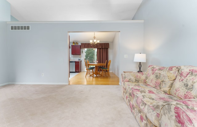 carpeted living room featuring a notable chandelier and lofted ceiling