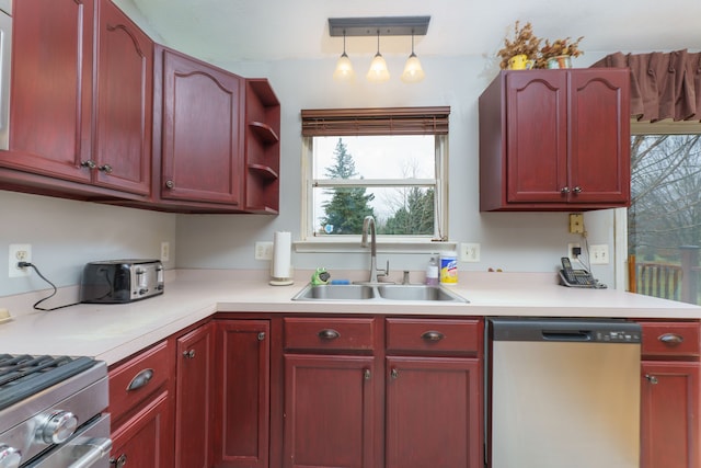 kitchen with track lighting, stainless steel dishwasher, hanging light fixtures, and sink