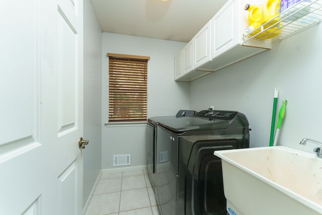 washroom with separate washer and dryer, sink, light tile patterned floors, and cabinets