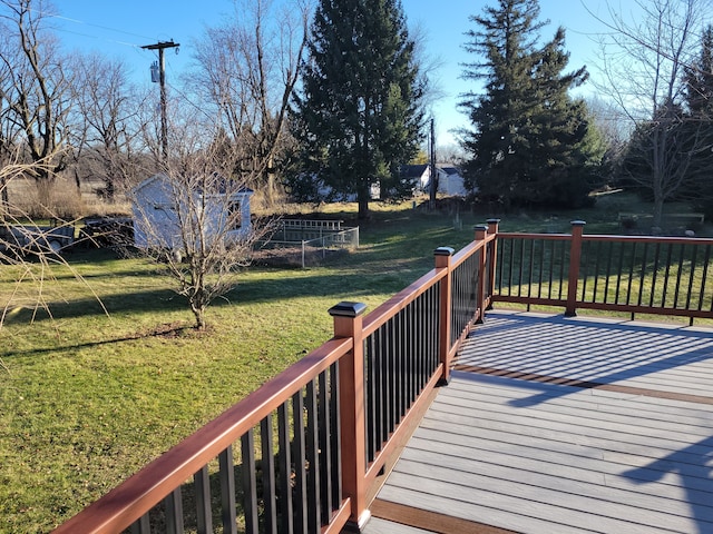 wooden terrace featuring a yard and a storage shed