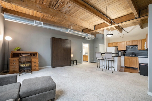 living room with beam ceiling, sink, light colored carpet, and wood ceiling