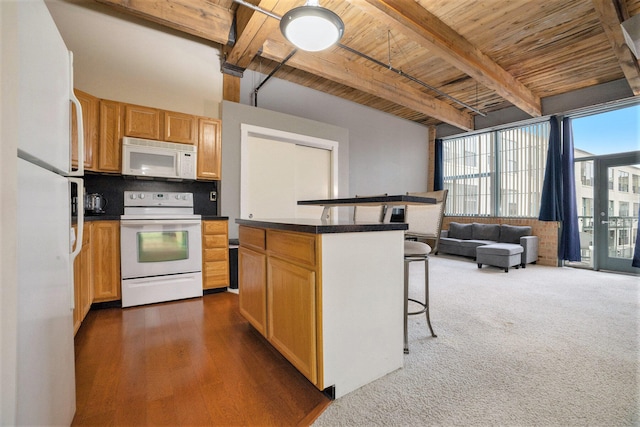 kitchen featuring beam ceiling, wooden ceiling, a kitchen breakfast bar, white appliances, and a kitchen island