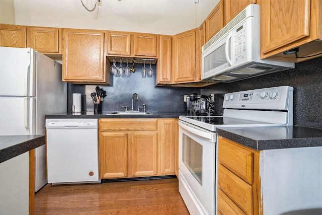 kitchen with backsplash, dark hardwood / wood-style flooring, sink, and white appliances