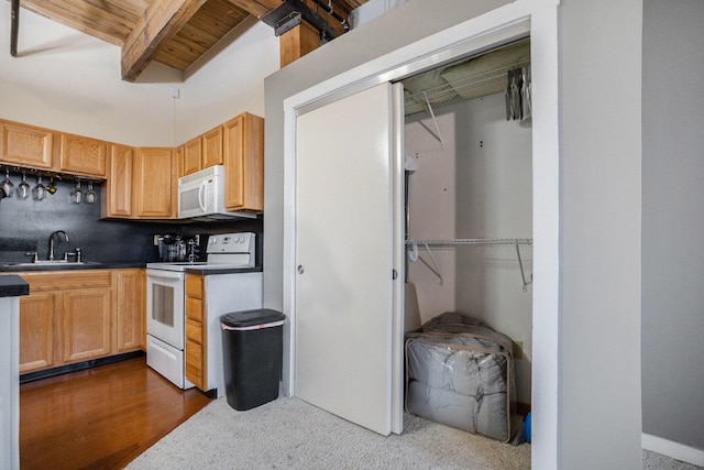 kitchen featuring white appliances, dark wood-type flooring, wooden ceiling, sink, and vaulted ceiling with beams