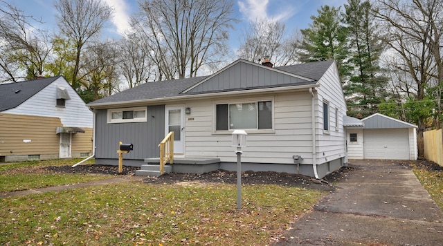 bungalow with an outbuilding, a garage, and a front lawn