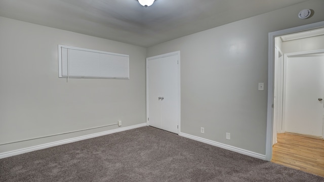 spare room featuring dark colored carpet