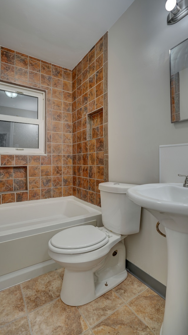 bathroom featuring tile patterned floors, tiled shower / bath combo, and toilet