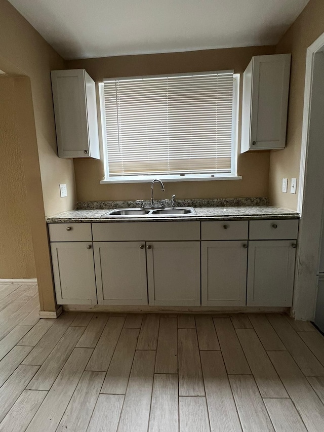 kitchen featuring a sink and light wood-style flooring