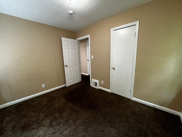 unfurnished bedroom featuring visible vents, carpet flooring, and baseboards