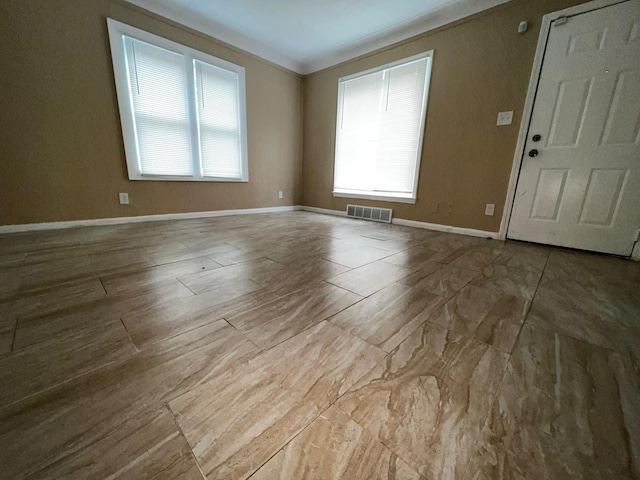 unfurnished room featuring visible vents, baseboards, and a healthy amount of sunlight
