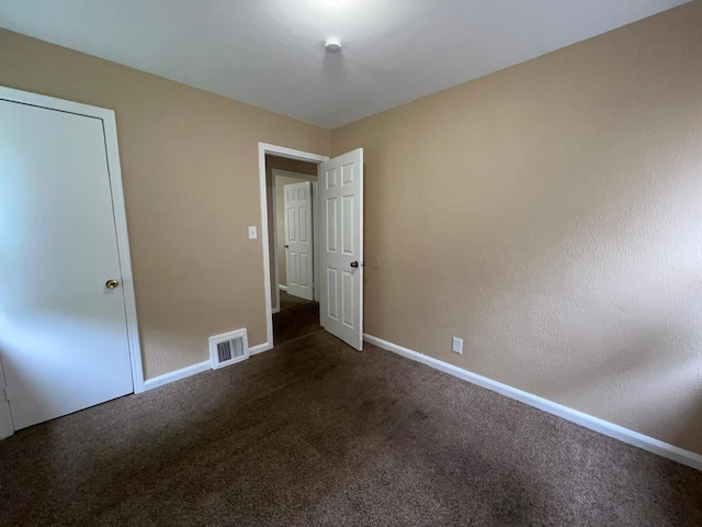 unfurnished bedroom featuring baseboards, carpet flooring, and visible vents