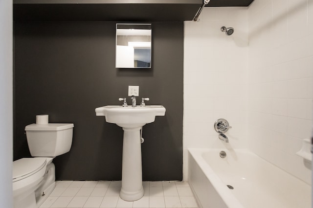 bathroom with tile patterned flooring, toilet, and tiled shower / bath