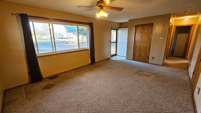 carpeted spare room with ceiling fan