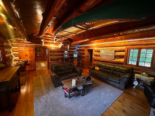 interior space featuring rustic walls, hardwood / wood-style floors, and beamed ceiling