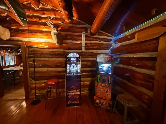 interior space featuring rustic walls, vaulted ceiling with beams, and hardwood / wood-style flooring