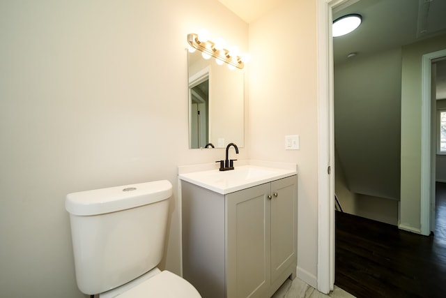 bathroom with hardwood / wood-style floors, vanity, and toilet