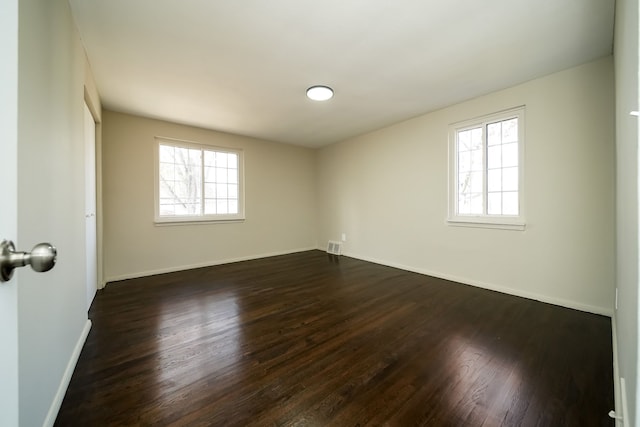 unfurnished room with a healthy amount of sunlight and dark hardwood / wood-style floors