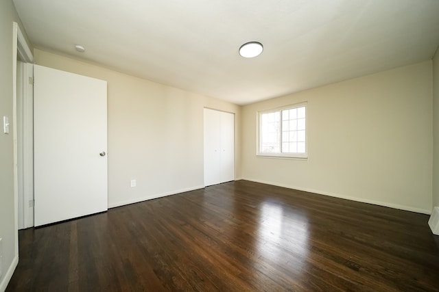 empty room with dark hardwood / wood-style flooring