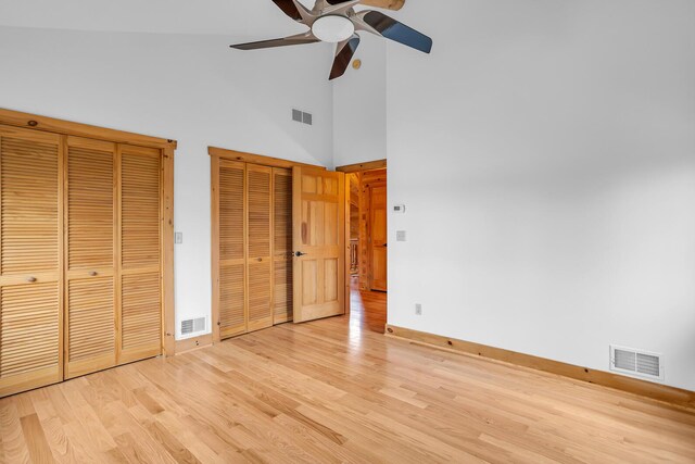 10560 Plaza Ct, Jerome, MI 49249 - unfurnished bedroom featuring baseboards, light wood-type flooring, multiple closets, high vaulted ceiling, and a ceiling fan