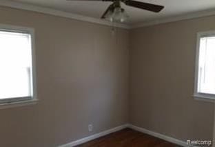 spare room featuring ceiling fan, ornamental molding, and a wealth of natural light