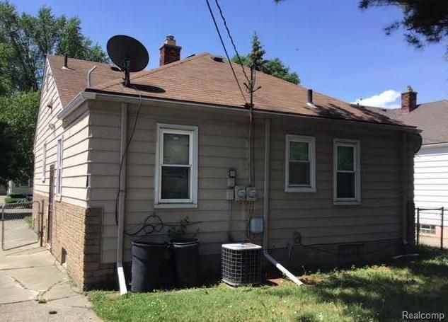 view of home's exterior with central AC unit and a lawn