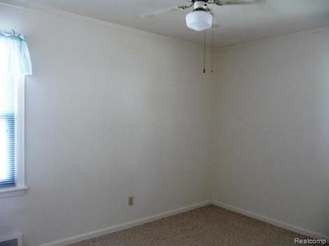 empty room featuring ceiling fan and carpet floors