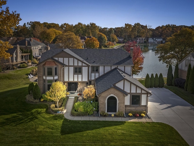 view of front of property with a water view and a front lawn