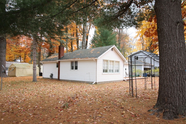 rear view of property with an outdoor structure