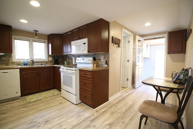 kitchen with light hardwood / wood-style floors, white appliances, sink, and tasteful backsplash