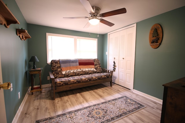 living area with ceiling fan and light hardwood / wood-style flooring