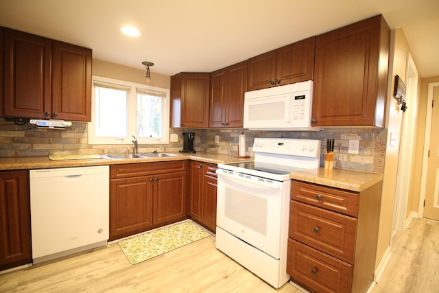kitchen featuring decorative backsplash, sink, light hardwood / wood-style floors, and white appliances