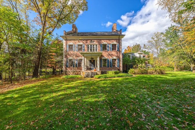 colonial-style house featuring a front lawn