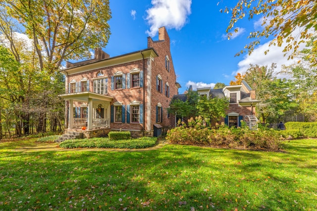 colonial inspired home with covered porch and a front yard