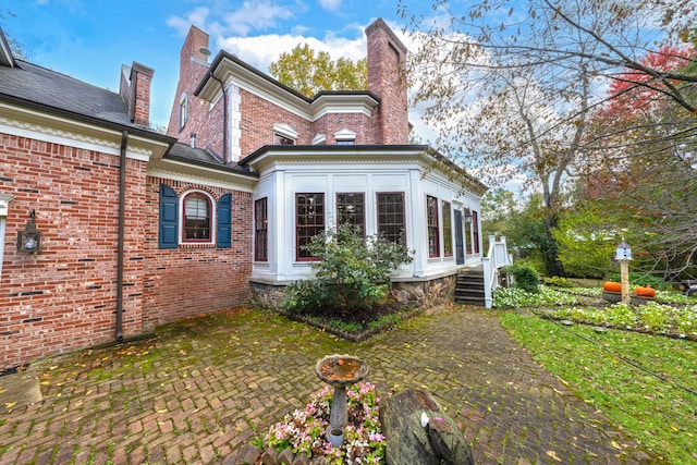 rear view of house featuring a sunroom and a patio area