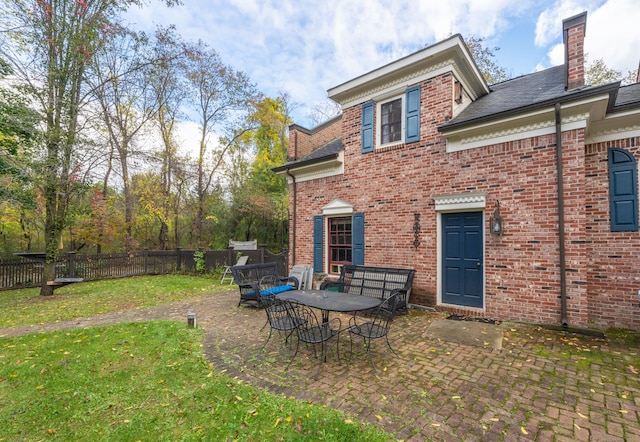 rear view of property with a yard and a patio