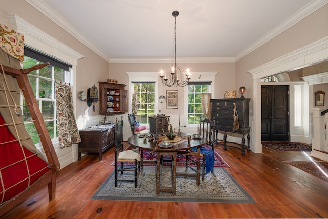 dining room featuring ornamental molding, an inviting chandelier, and dark wood-type flooring