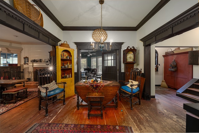 living area with ceiling fan with notable chandelier, dark hardwood / wood-style floors, and ornamental molding